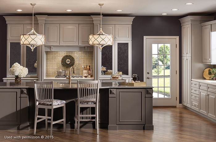 A white, blue and gray kitchen remodel features flowers and coffee sitting on the kitchen island, and two hanging white lights illuminating the room.