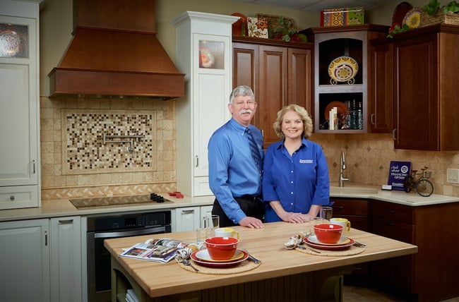 DreamMaker franchise owners Glen and Denise Borkowski pose for a photo in a model kitchen in their Design Center.