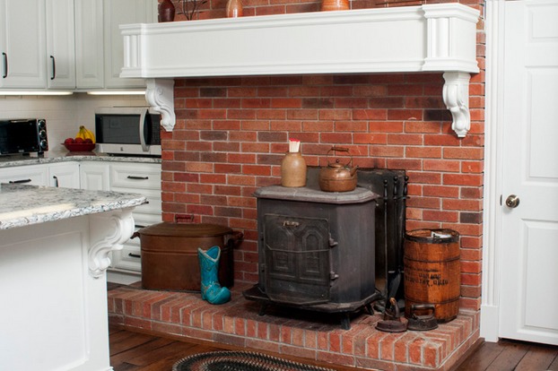 The hearth is now a focal point in the room since it contrasts with the bright countertops and cabinetry.